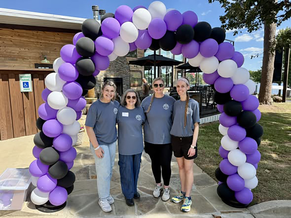 Four women under a balloon arch