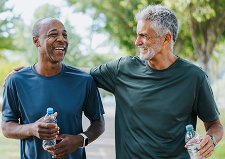 Two men walking holding a water bottle