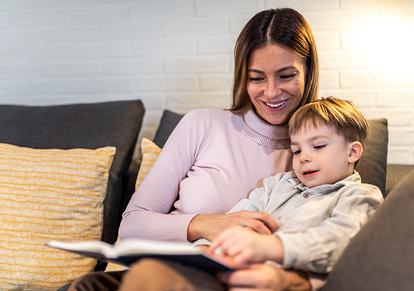 A mom reads a book with her young son at the Ronald McDonald House