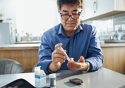 Asian man checking his blood sugars